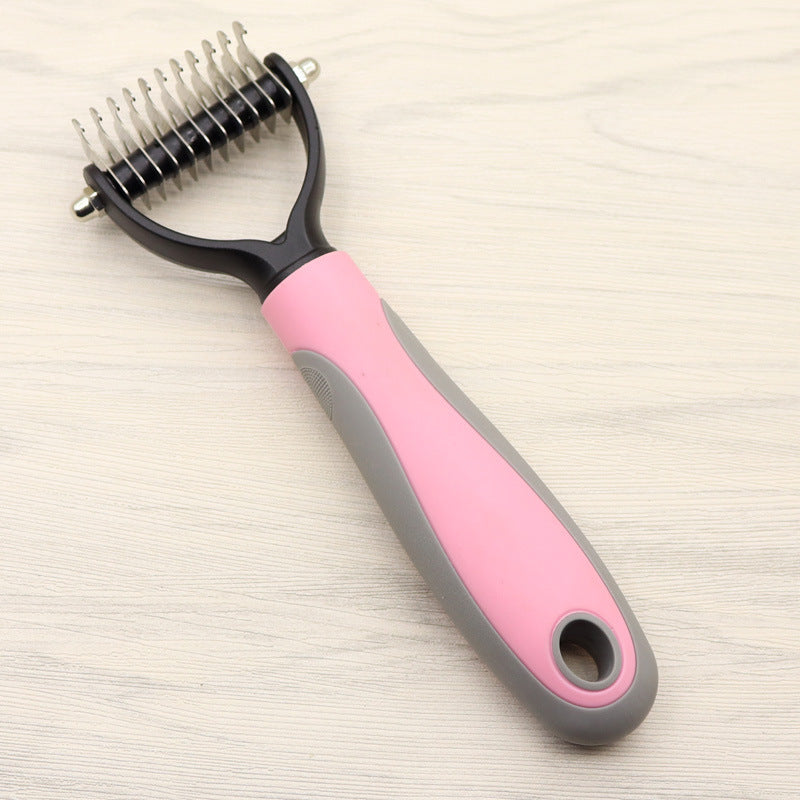 Two dog grooming combs with pink and blue handles side by side on wooden surface