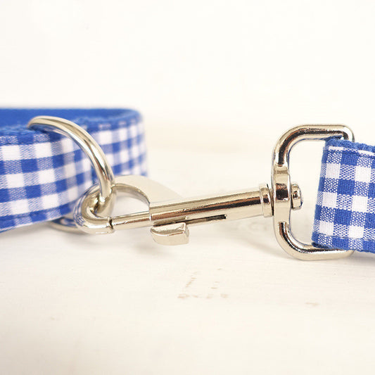 Close-up of metal clasp on blue plaid dog leash
