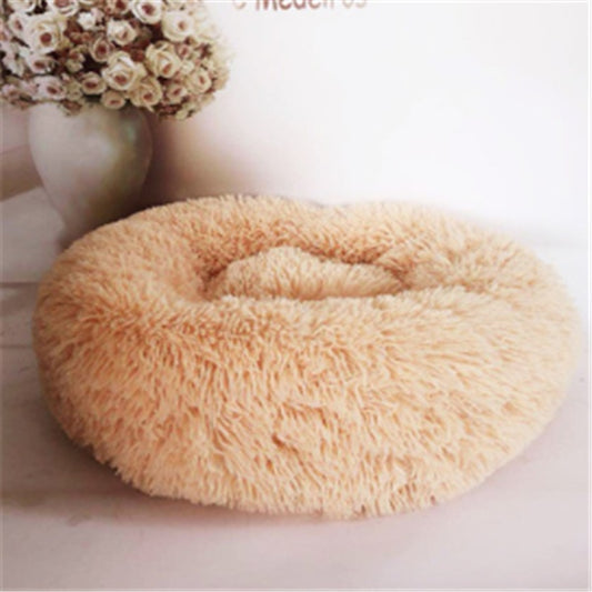 Round beige plush pet bed displayed with floral background