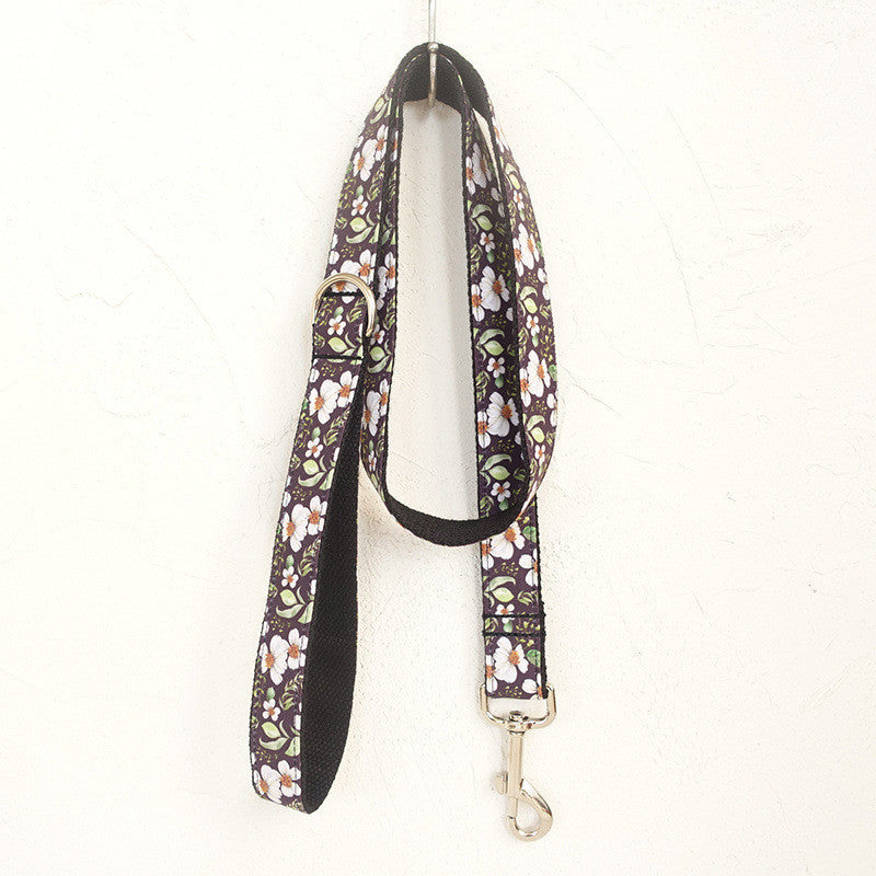 Matching floral dog leash hanging against a textured white wall