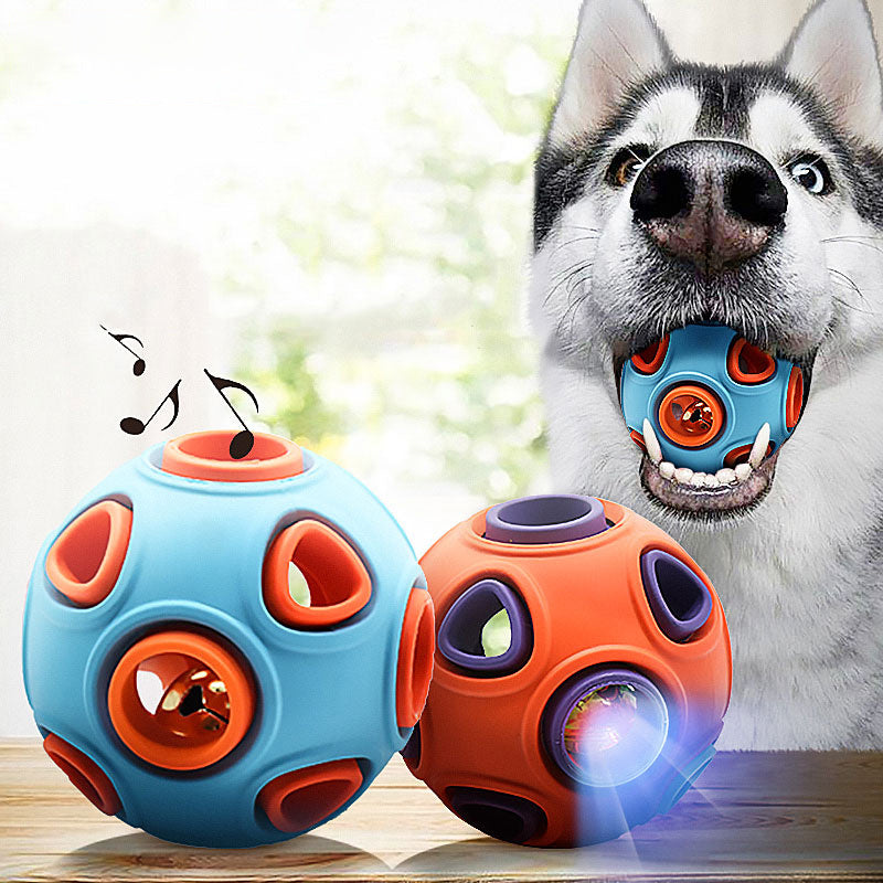 Two colorful dog toy balls with holes and bells inside, one blue and orange, the other orange and purple, shown with a dog holding the blue ball in its mouth.