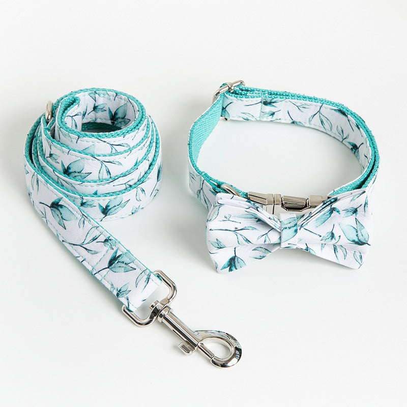 Rolled leash next to matching collar with bow tie laid on white surface