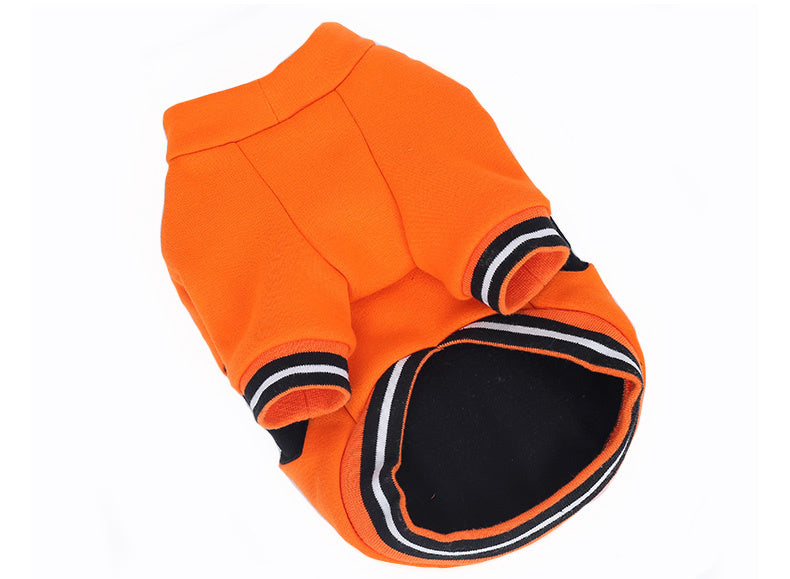 Flat lay of pumpkin dog sweater showing striped black and white cuff sleeves and opening