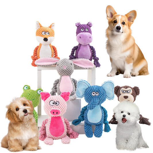 Group of colorful plush animal rope dog toys with three dogs sitting nearby