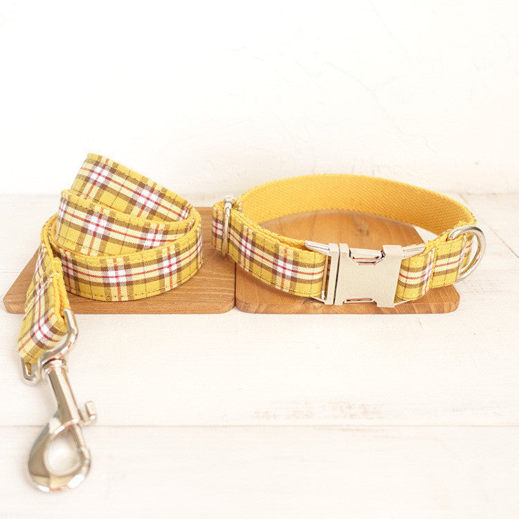 Yellow plaid dog collar and matching leash placed on wooden boards