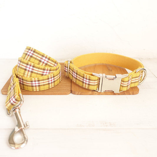 Yellow plaid dog collar and matching leash placed on wooden boards