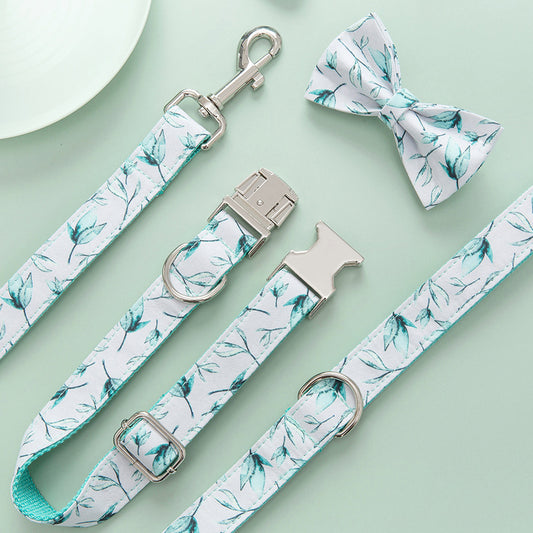 Close-up of leaf patterned leash, collar, and detachable bow tie on light green background