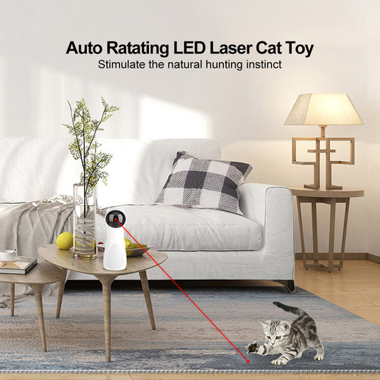 Automatic rotating LED laser cat toy on wooden table with red light stimulating a kitten on carpet in living room