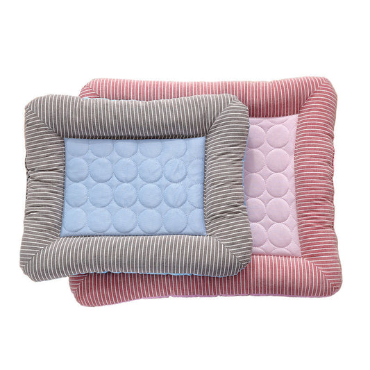 Two striped quilted cooling pet beds stacked, smaller blue bed on top of larger pink bed.