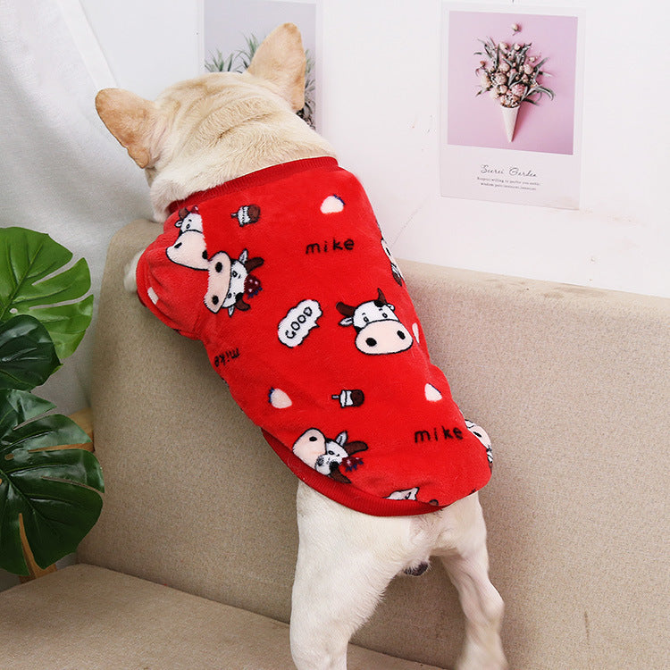 Dog seen from behind wearing red coral fleece pajamas with cow cartoon print