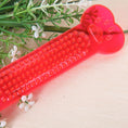 Load image into Gallery viewer, Close-up of red transparent PVC dog bone toy showing raised paw print and bumpy textured center
