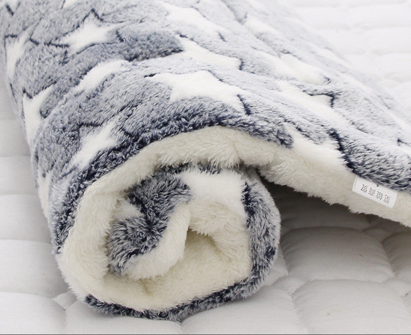 Close-up of plush star pattern pet blanket rolled with visible fleece edge