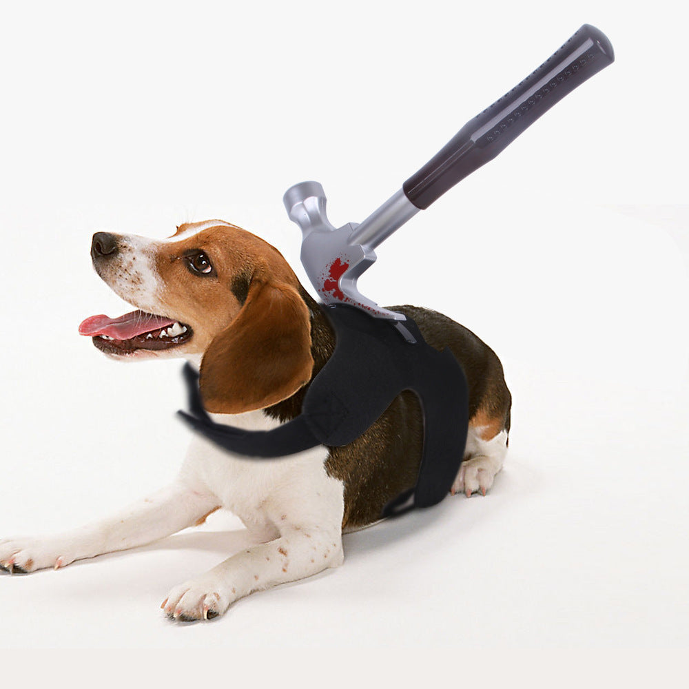 Beagle dog lying down wearing black Halloween harness with bloodied hammer prop on back