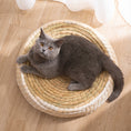 Load image into Gallery viewer, Top view of a gray cat resting inside a circular woven straw cat bed near sheer curtains
