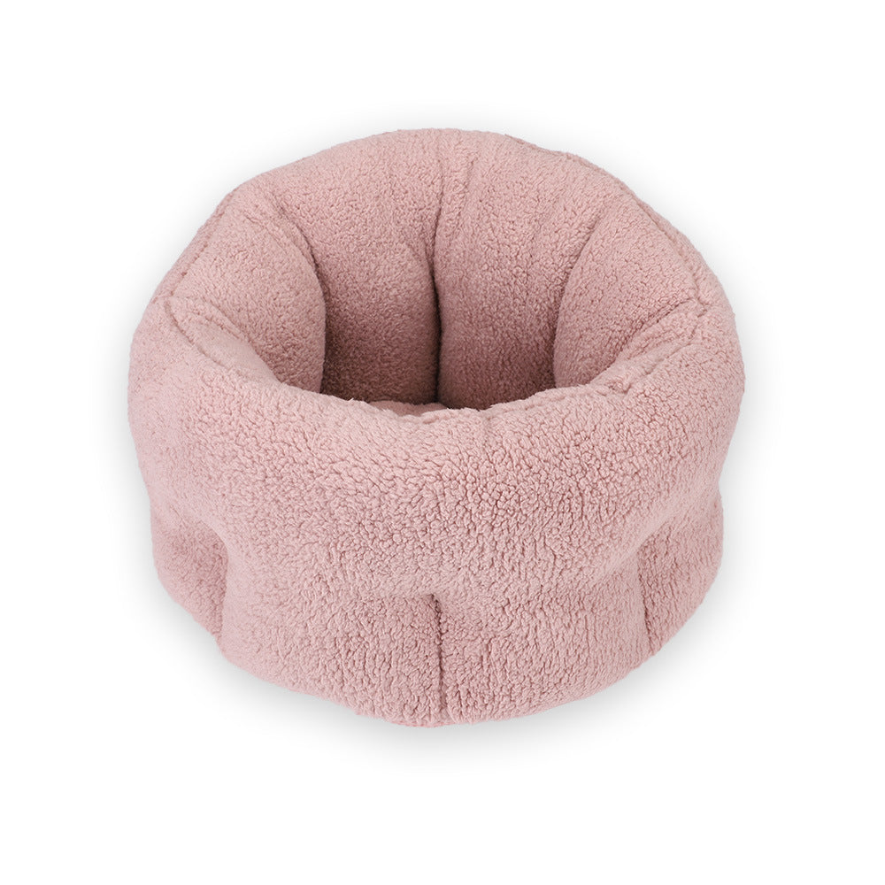 Soft pink plush round pet bed shown isolated on white background