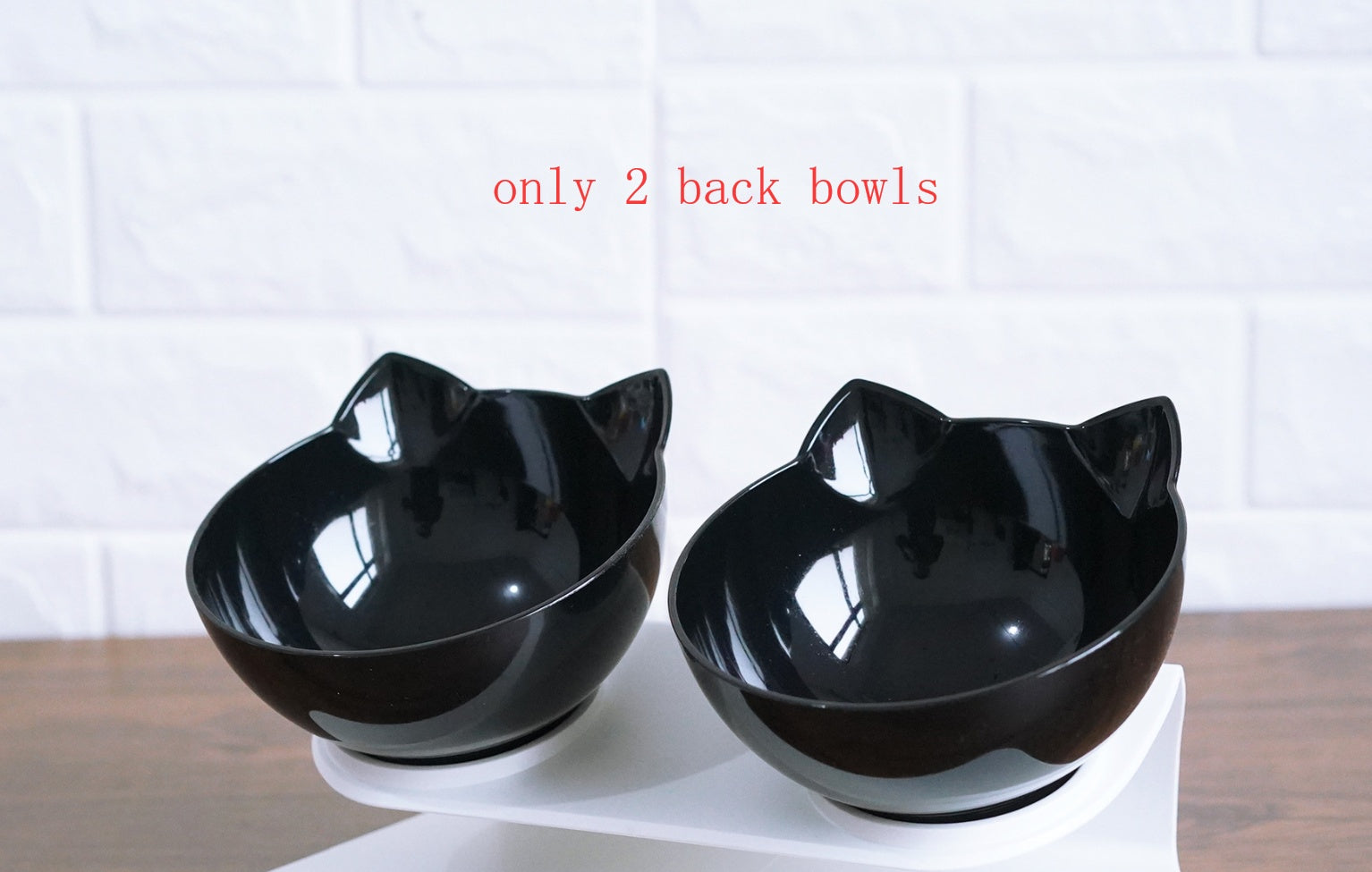 Top view of two clear transparent cat ear bowls on white elevated stand
