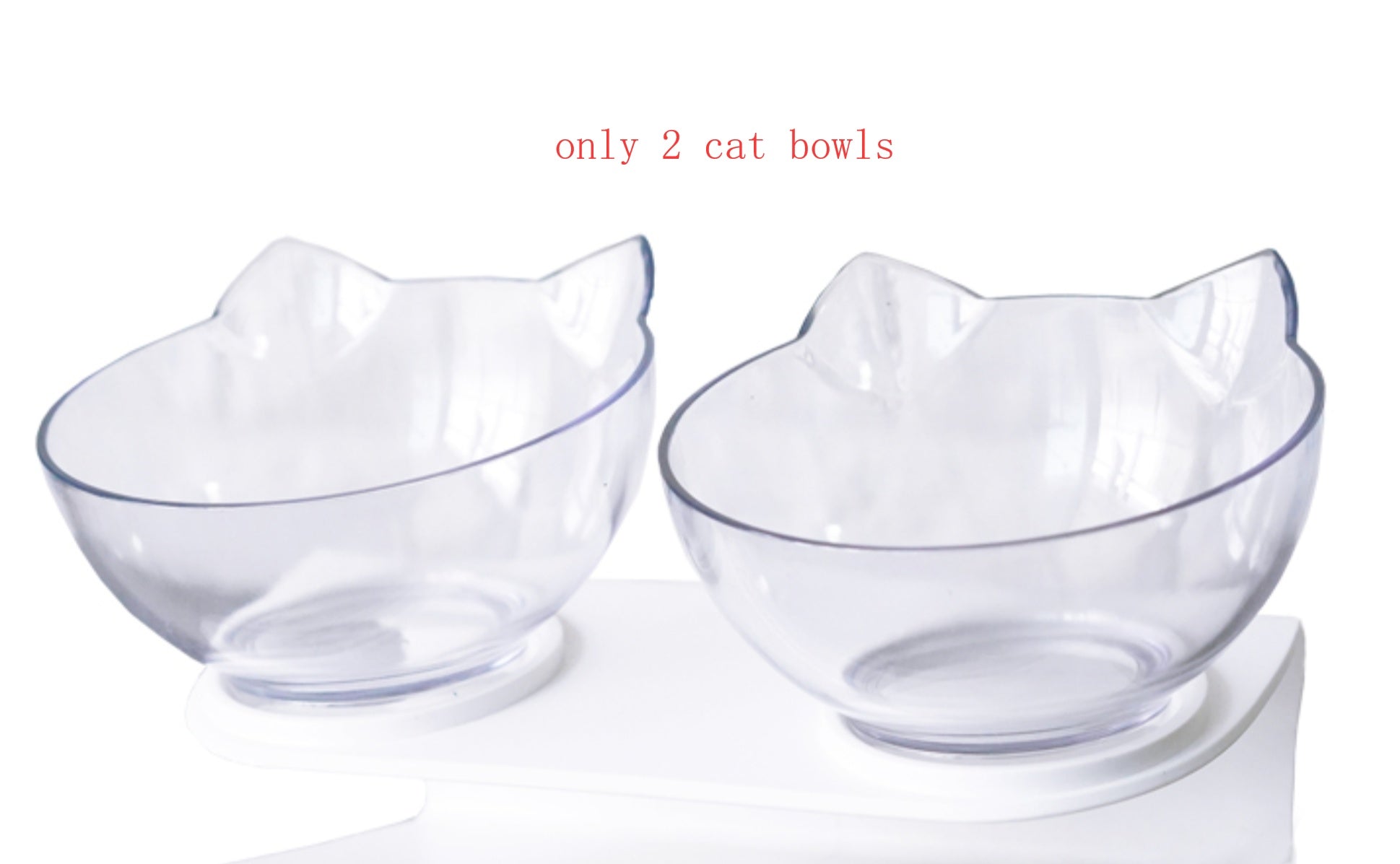 Pair of clear cat ear bowls on white elevated stand photographed against white brick wall