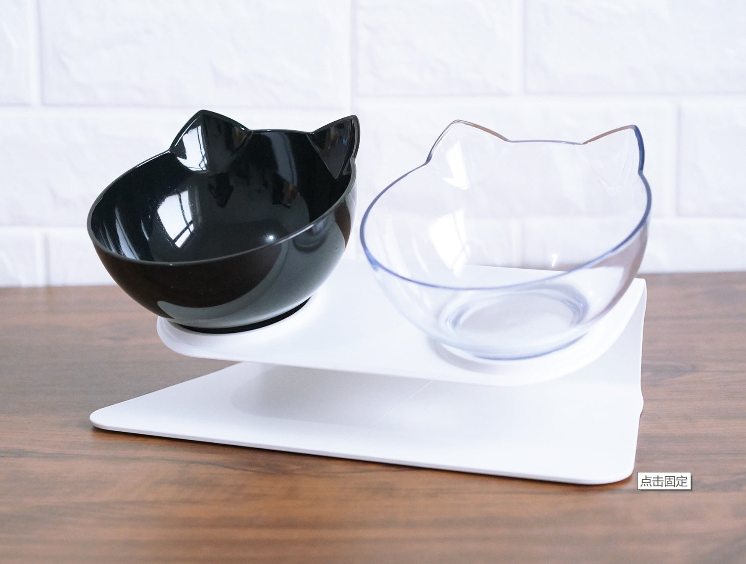 Two cat-ear bowls on white elevated stand, black bowl on left and transparent bowl on right