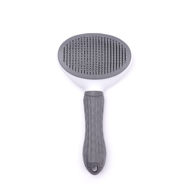 Top view of a grey and white detachable pet grooming brush with metal bristles