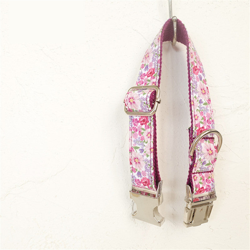 Pink floral dog collar hanging by metal buckle on wall hook
