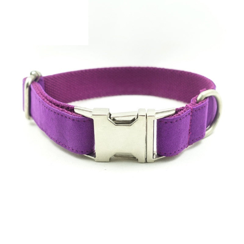 Close-up image of rolled purple velvet dog leash with metal clasp on white background.