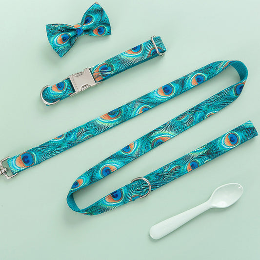 Peacock print dog collar, leash, and matching bow tie displayed on a mint green background