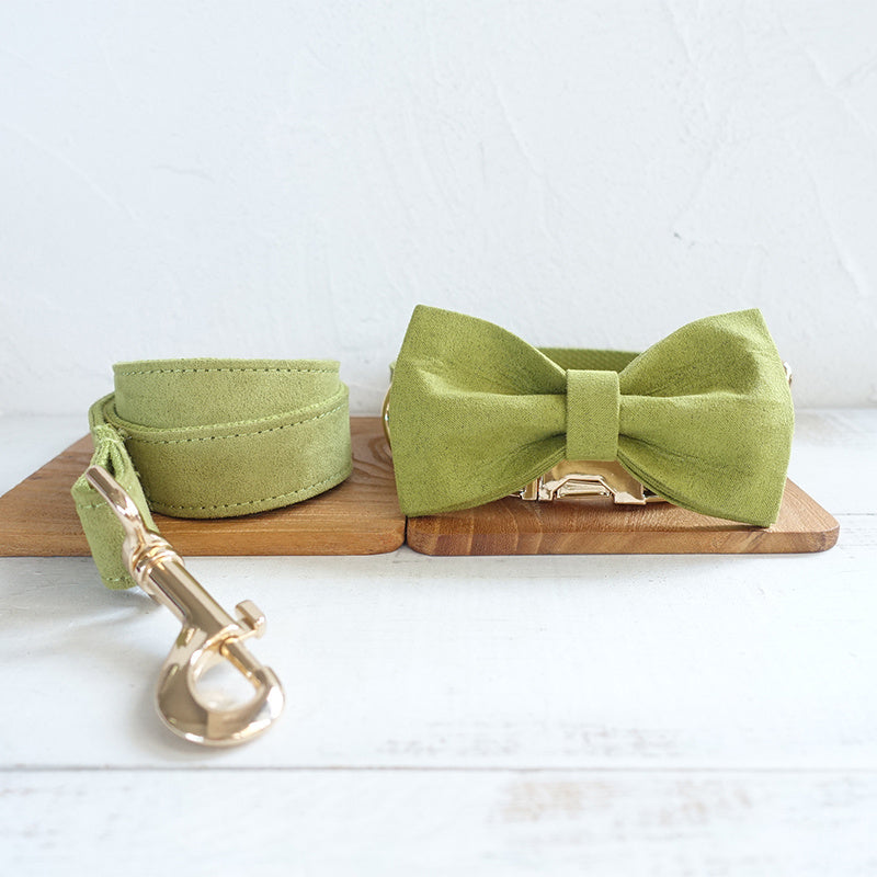 Green polyester dog leash and collar with matching bow tie accessory displayed on wooden surface
