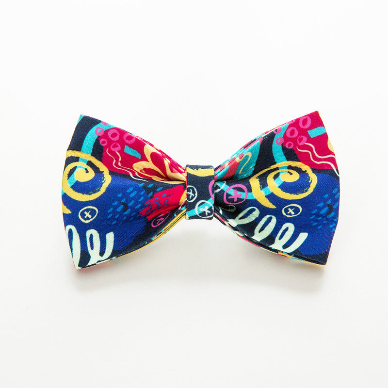 Vibrant dog bow tie with multicolor graffiti print on white background