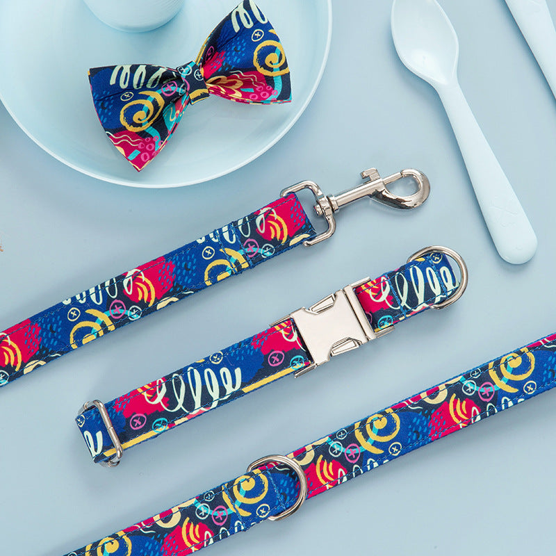Colorful graffiti pattern dog collar, leash, and matching bow tie set laid on blue background