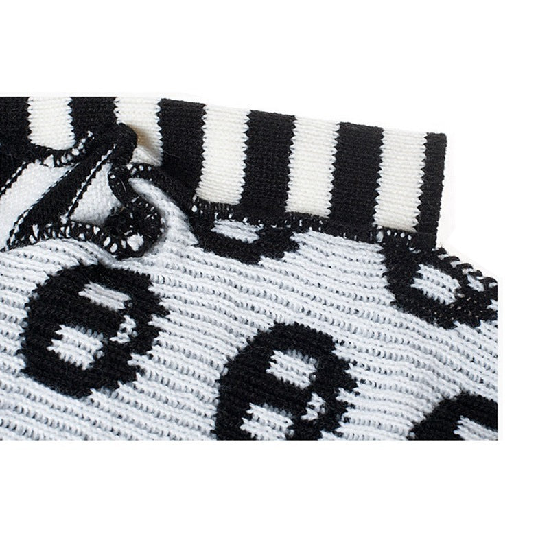 Close-up of knit fabric showing black and white skull pattern and striped collar