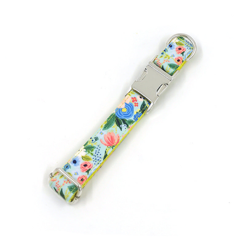 Adjustable floral dog collar with metal buckle and D-ring on white background