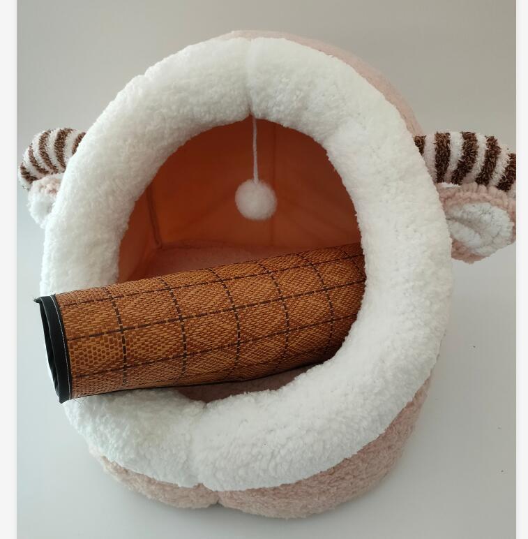 Light peach and white plush cat cave bed with striped ram-like ears, rolled mat inside