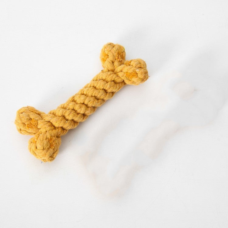 Close-up of yellow braided cotton rope dog chew toy bone shape on white background