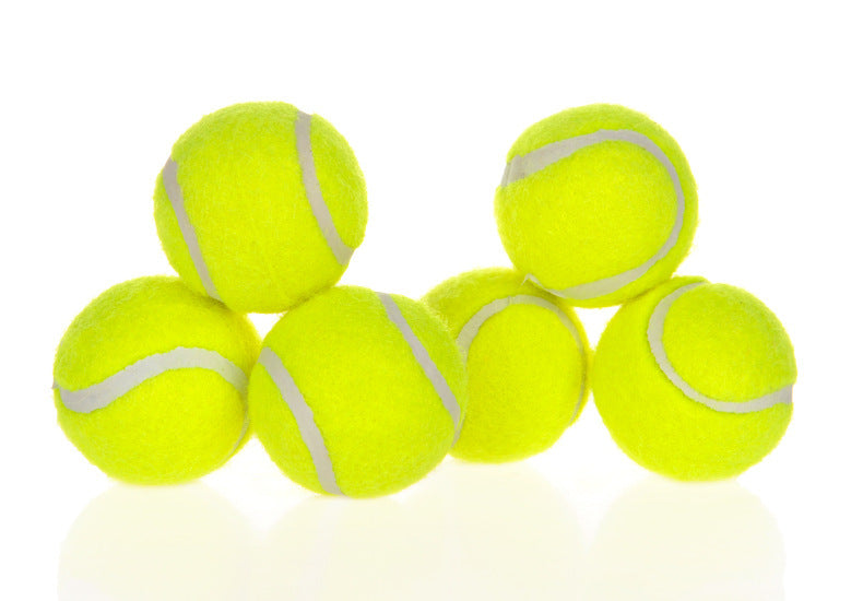 Heap of standard 2 inch yellow tennis balls stacked together on white background