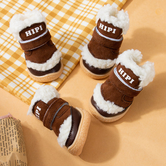 Four brown winter dog booties with white fleece lining and rubber soles placed on yellow background near a folded newspaper