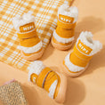 Load image into Gallery viewer, Close-up of four mustard yellow winter dog booties with thick white fleece lining and sturdy rubber soles on neutral surface

