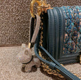 Charger l'image dans la visionneuse de la galerie, Crystal dog keychain attached to a dark green textured handbag with gold chain handles, emphasizing the crystal charm
