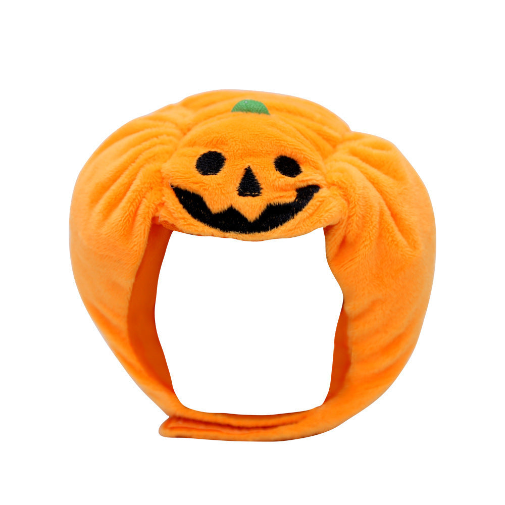 Front view of the bright orange velvet pumpkin pet hat with jack-o'-lantern embroidery and adjustable strap