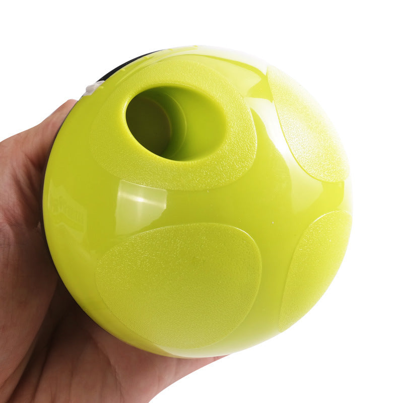 Hand holding lime green egg-shaped pet food dispenser with textured grip and feeding hole