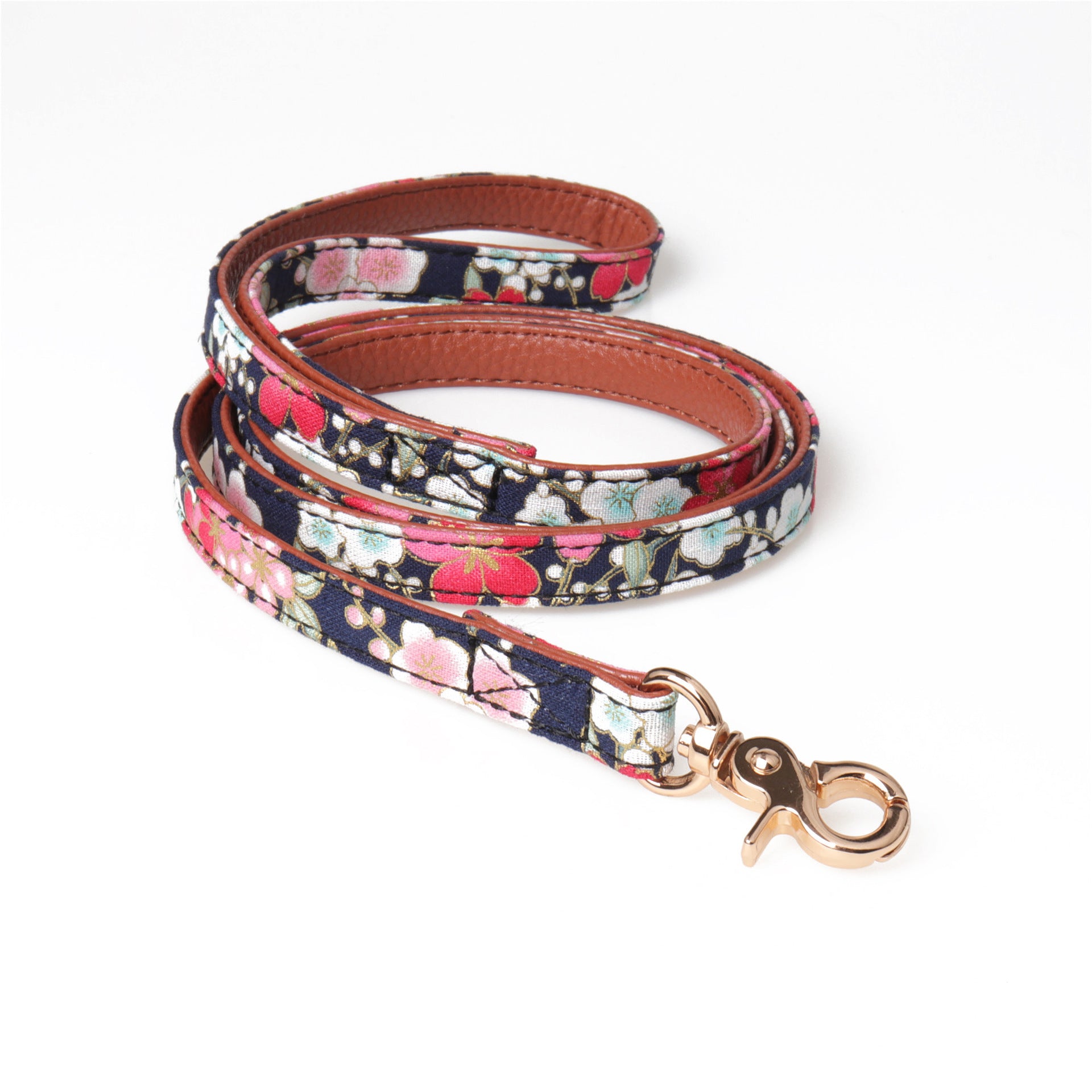 Floral patterned leash with gold metal clasp shown neatly coiled