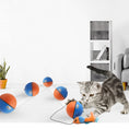 Load image into Gallery viewer, Gray tabby kitten playing with orange and blue moving ball connected to a feather mouse on white floor
