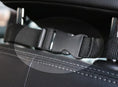 Cargar la imagen en la vista de la galería, Close-up of black adjustable buckle strap securing car seat cover to headrest
