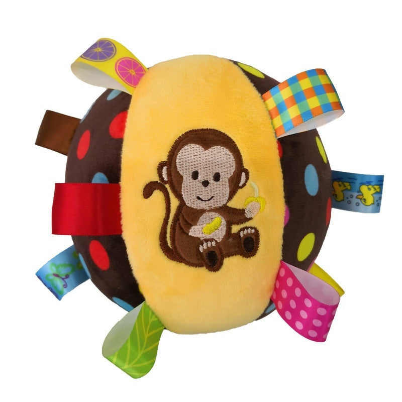 Brown and yellow plush dog toy ball featuring an embroidered monkey and colorful ribbon loops