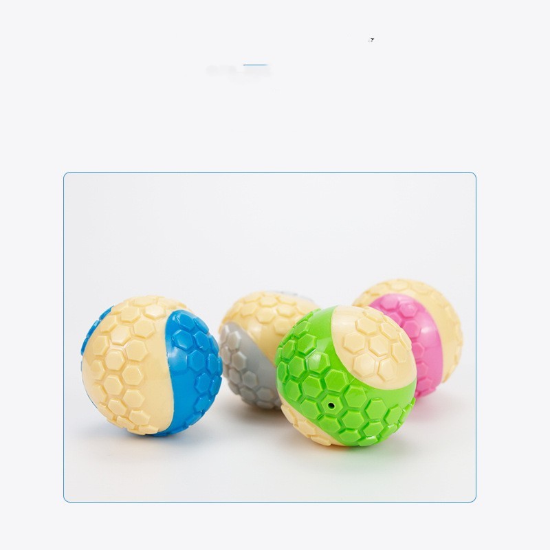 Four textured dog chew balls in blue, green, gray, and pink colors arranged together