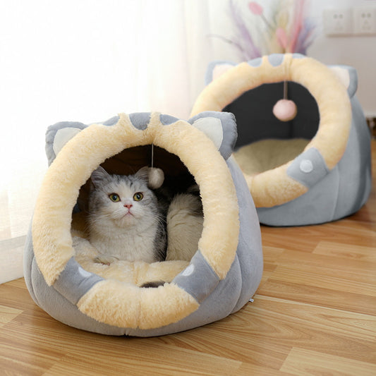 Gray and cream plush cat cave shaped like an animal with ears and a hanging ball inside, featuring a gray and white cat resting inside.