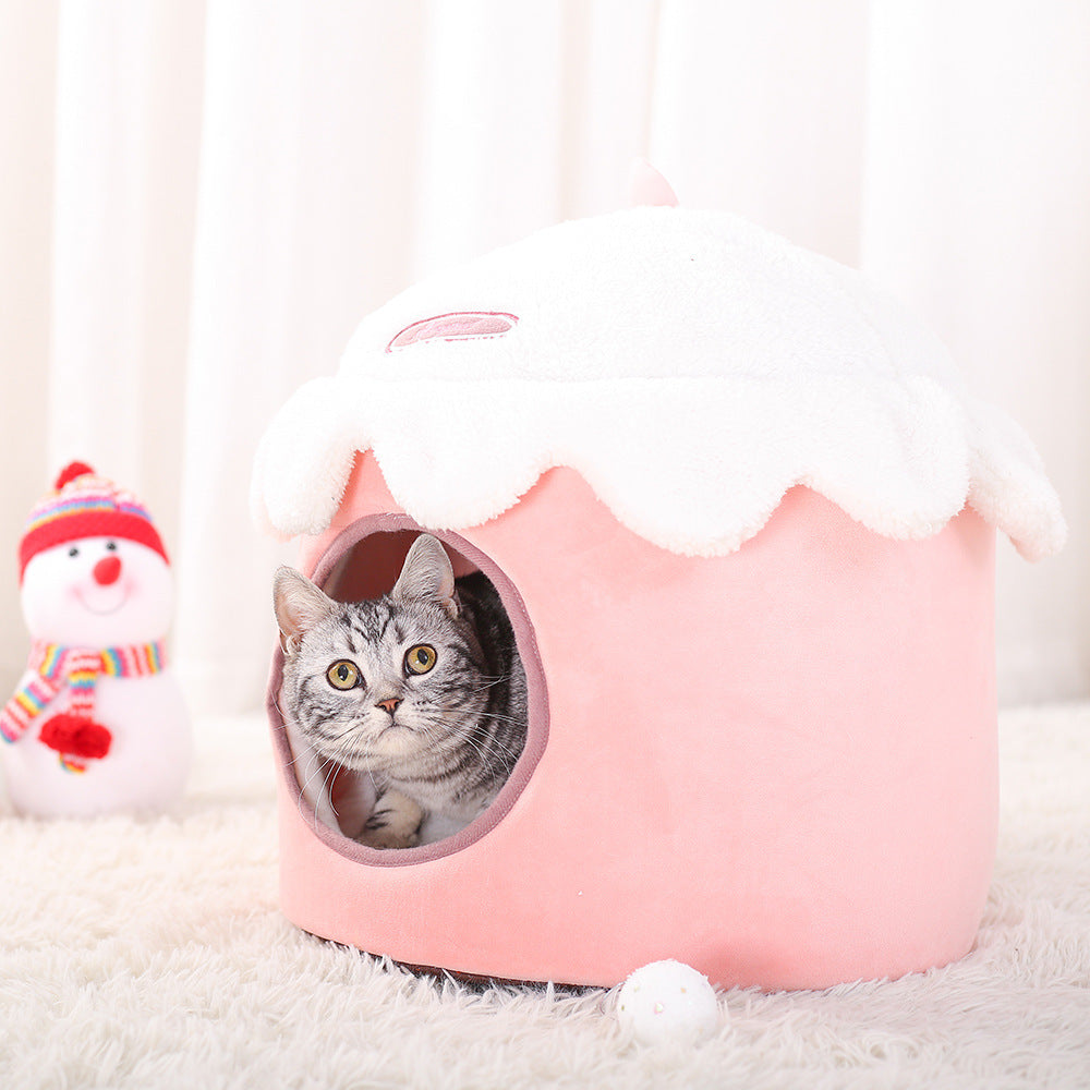 Grey tabby cat inside pink ice cream shaped plush winter cat nest with white fleece top