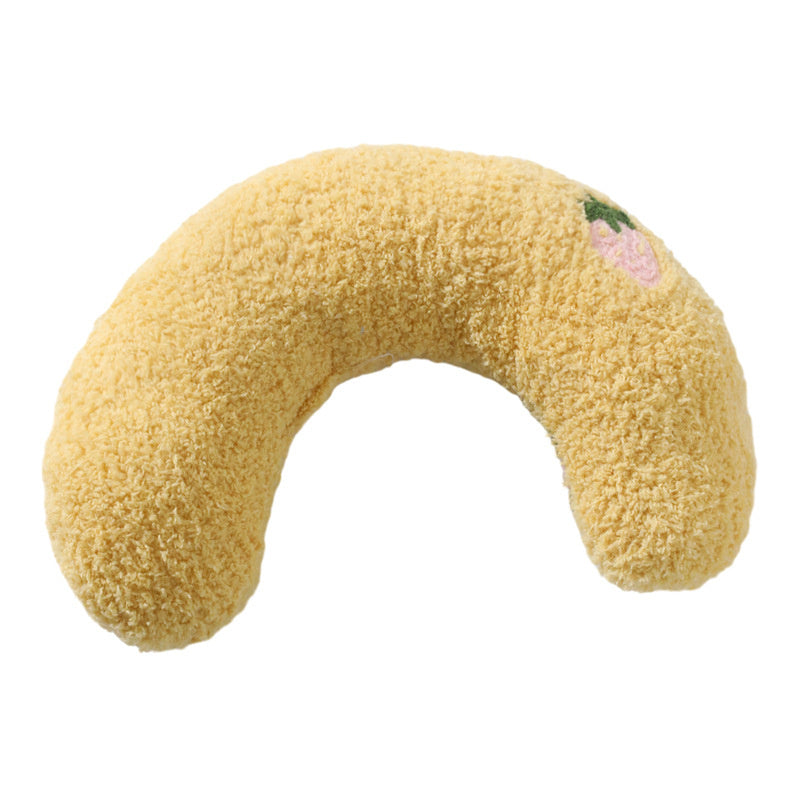 Yellow U-shaped plush pet pillow with pink flower embroidery on white background