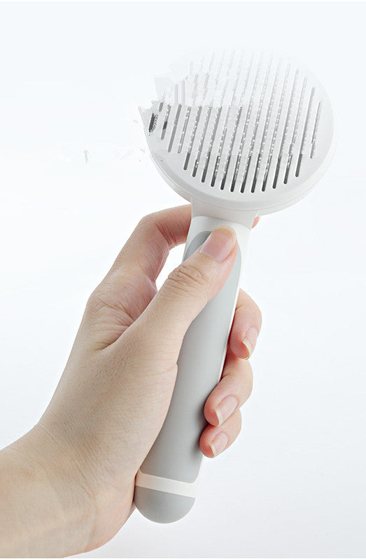 Close-up of gray handled pet hair comb showing needle design and round head