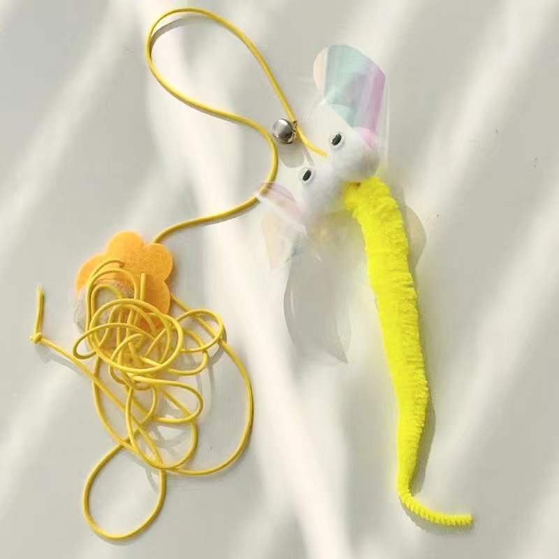 Yellow fuzzy fish-shaped cat toy with translucent fins attached to yellow elastic cord on white background
