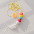 Cargar la imagen en la vista de la galería, Colorful caterpillar plush toy with feather tail and yellow elastic rope on white surface
